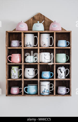 Keramik Kaffeetassen auf handgefertigten Holzmöbeln rustikal Wandregal Stockfoto