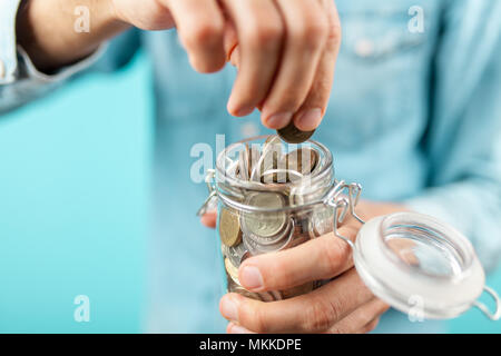 Mann hält eine Münze jar Stockfoto