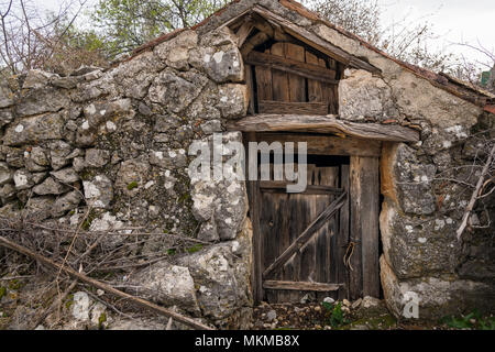 Sehr alte verwitterte braune Tür aus Holz, Stein (Insel Cres, Kroatien) Stockfoto