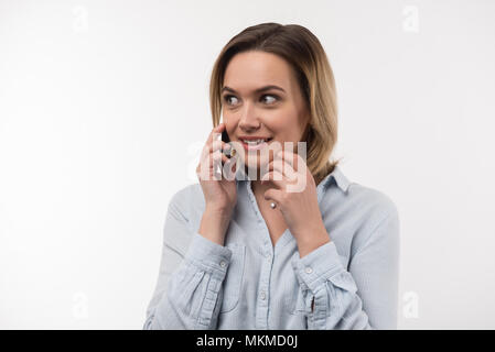 Nette Frau das Telefon an Ihr Ohr erfreut Stockfoto