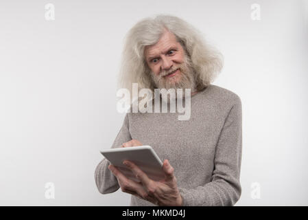 Happy netter Mann mit einem digitalen Gerät Stockfoto