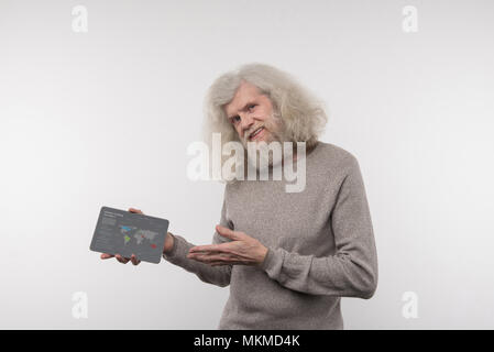 Positive freudige Mann hält eine Tablette Stockfoto