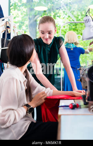 Weibliche Mode Designer im Gespräch in der Werkstatt Stockfoto