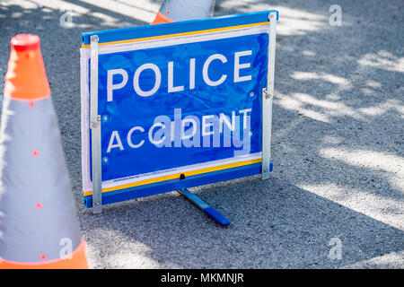 Erhöhten Blick auf den freistehenden POLIZEI UNFALL Schild am Straßenrand mit zwei leitkegel. Stockfoto