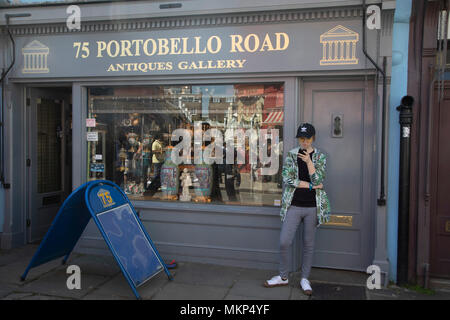 Menschen außerhalb der Portobello Road Antigues Galerie in Notting Hill, London, England, Vereinigtes Königreich. Menschen in sonniger Tag heraus hängen auf dem berühmten Markt am Sonntag, wenn die antiken Ständen säumen die Straße. Portobello Market ist die weltweit größte Antiquitätenmarkt mit über 1.000 Händler verkaufen jede Art von Antiquitäten und Sammlerstücke. Besucher aus aller Welt an einem von Londons beliebtesten Straßen zu gehen. Stockfoto