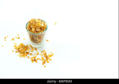 Brauner Zucker in ein kleines Glas auf weißem Hintergrund Stockfoto