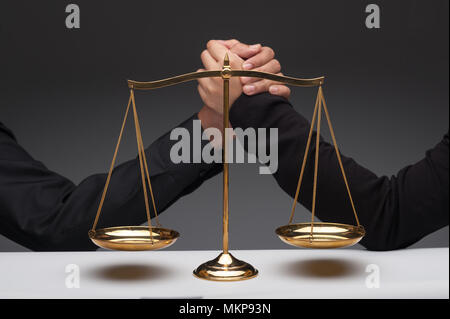 Nahaufnahme von Menschen gemeinsam vor Skala Gleichgewicht kämpfen. Arm Wrestling. Interessenkonflikt. Konzepte von Recht und Gerechtigkeit. Stockfoto