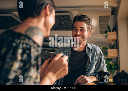 Schöner Mann im Gespräch mit seiner Freundin in einem Café. Paar Begegnung in einem Coffee Shop. Stockfoto