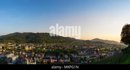 Deutschland, XXL Panorama der Stadt Freiburg im Breisgau in der Dämmerung im warmen Abendlicht Stockfoto