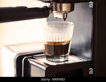 Espresso Tasse mit Kaffee Maschine ausgießen Tropfen, morgens Kaffee selektive, Fokus Stockfoto