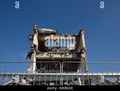 Sicherheitsbarriere vor teilweise abgerissenen Stahlbeton Multi Geschoss Gebäude und Betonschutt auf Abbruchstelle in Bury lancashire uk Stockfoto