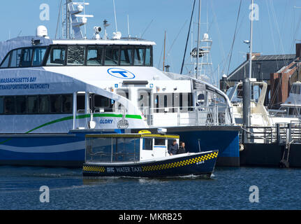 Ein Boston Harbor Wassertaxi übergibt einen Angedockten Pendler Boot in den Hafen. Boston, Massachusetts, USA Stockfoto