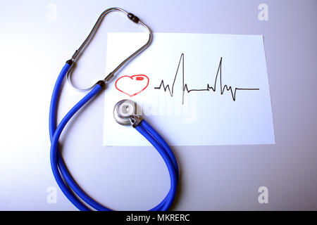 Mit medizinische Stethoskop und Arzt Mantel auf Tabelle Elektrokardiogramm. Stockfoto