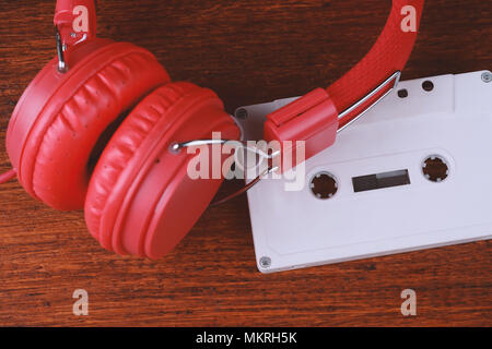 Blick von oben auf die vintage Kopfhörer und Audio Cassette auf Holztisch. Retro Technologie Konzept