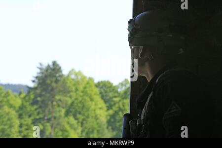 Us-Armee Pfc. Justin Dovos, 1.BATAILLON, 4 Infanterie Regiment, die Teil des Multi-nationalen Kräfte Bataillon opposition Kraft für das bevorstehende Blau Kraft Platoon der 12 polnischen Mechanisierte Division während der Joint Warfighting Bewertung (JWA), Grafenwöhr, Deutschland, Mai 7, 2018, 7. Mai 2018. JWA hilft die Armee aufkommende Konzepte zu bewerten, neue Technologien zu integrieren und Interoperabilität innerhalb der Armee zu fördern, andere Dienstleistungen, US-Verbündeten und Partner. (U.S. Armee Foto: Staff Sgt. Julie Jaeger). () Stockfoto