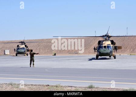 Einen afghanischen Luftwaffe Mitglied leitet zwei UH-60 Blackhawks, wie sie sich vorbereiten, für die erste Afghanische zu nehmen - die Mission auf diesem Flugzeug Mai 8, 2018 Led, Kandahar Air Field, Afghanistan, 8. Mai 2018. Die Mission, die zur Unterstützung der Wahlen war, ereignete sich nur einen Tag nachdem die Mannschaften von Mission Qualifizierung Ausbildung absolvierte. (U.S. Air Force Foto/1 Lt Erin Recanzone). () Stockfoto