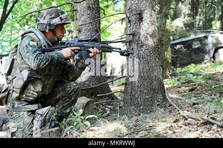 Ein albanischer Soldat mit Alpha Company, Commando Bataillon, in eine kniende Kampfstellung in Hohenfels, Hohenfels, Deutschland bekommt, während der kombinierten Lösung X, Mai 06, 2018, 6. Mai 2018. Kombinierte Lösung X umfasst rund 3 700 Teilnehmer aus 13 Nationen an der 7th Army Training Befehl Grafenwöhr und Hohenfels Training Area, 9. April, 12. Mai 2018. Kombinierte Lösung ist ein US-Army Europe - Regie multinationale Übung Serie entwickelt, um die Armee des zugewiesenen regional zu kampfbrigaden nach Europa ein Combat Training Center Rotation mit Gelenk, multinationalen Envir geben Stockfoto