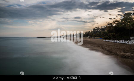 Lange Exposition von einem Strand in Marbella an der Costa del Sol in Spanien bei Sonnenuntergang im späten Frühling genommen. Stockfoto