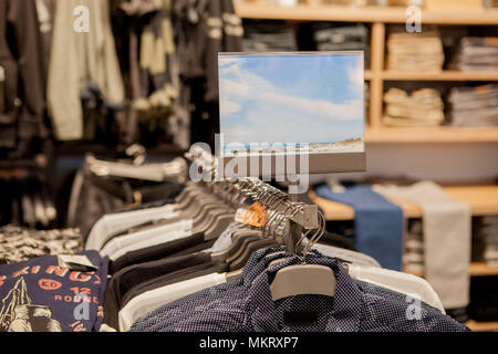 Herren Hemden in verschiedenen Farben auf Kleiderbügeln in einem Ladengeschäft. Showcase, Verkauf, shopping. Mode und Handel Konzept. Stockfoto