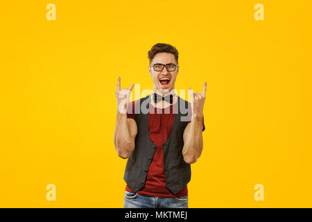 Portrait des jungen Mannes im stilvollen cooles Outfit und Gläser ausdrücklich posiert auf gelbem Hintergrund Stockfoto