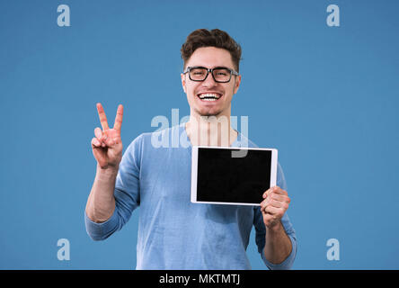 Happy hippie Mann in Gläser mit Tablet-PC den Sieg Zeichen