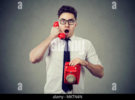 Erstaunt, entsetzt, jungen Mann auf einem Telefon Stockfoto