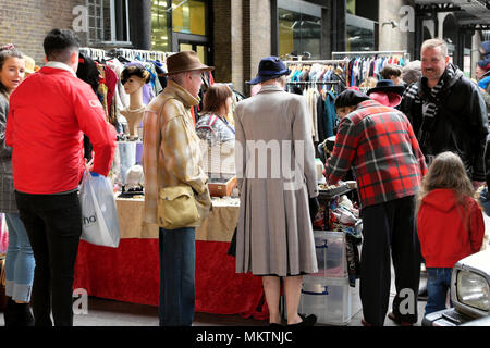 Rückansicht eines Paares im 1940s-Style-Bekleidungsmarkt auf der Vintage Car Boot Sale-Messe am Granary Square in Kings Cross London, Großbritannien, KATHY DEWITT Stockfoto