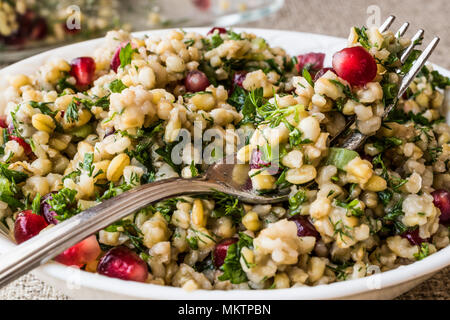 Weizen Salat mit Granatapfel in weiße Schüssel. Ökologische Lebensmittel Stockfoto