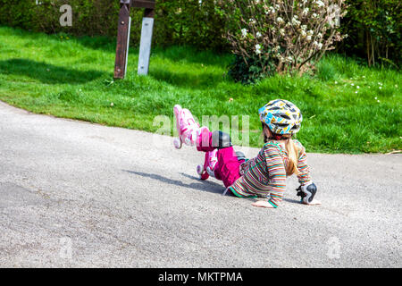 Mädchen fallen in der Straße mit ihren Rollen. Stockfoto