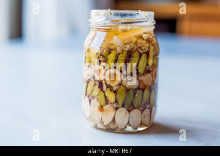 Honig mit Nüssen, Mandeln und Erdnuss Krokant Dessert im Glas. Ökologische Lebensmittel. Stockfoto