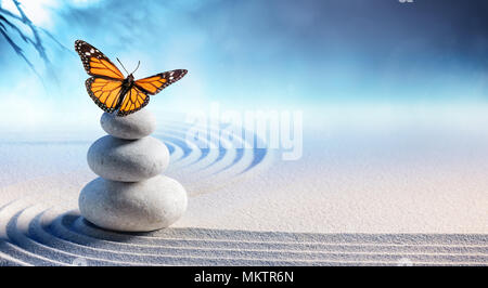 Schmetterling auf Spa Massage Steine in Zen Garten Stockfoto