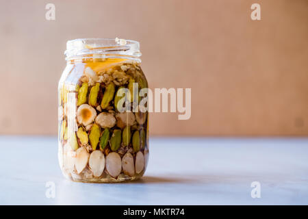 Honig mit Nüssen, Mandeln und Erdnuss Krokant Dessert im Glas. Ökologische Lebensmittel. Stockfoto