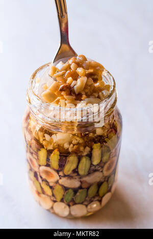 Honig mit Nüssen, Mandeln und Erdnuss Krokant Dessert im Glas. Ökologische Lebensmittel. Stockfoto