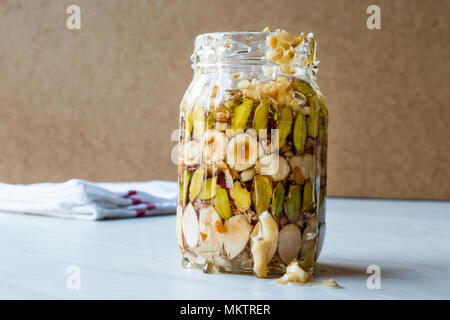 Honig mit Nüssen, Mandeln und Erdnuss Krokant Dessert im Glas. Ökologische Lebensmittel. Stockfoto