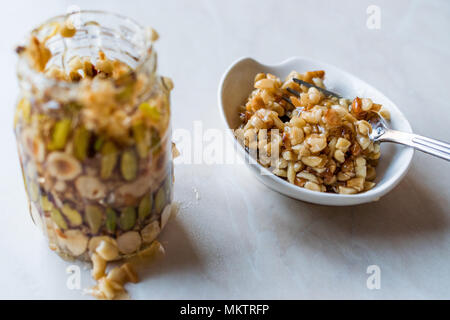 Honig mit Nüssen, Mandeln und Erdnuss Krokant Dessert im Glas. Ökologische Lebensmittel. Stockfoto