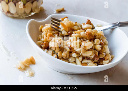 Honig mit Nüssen, Mandeln und Erdnuss Krokant Dessert. Ökologische Lebensmittel. Stockfoto