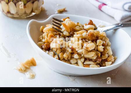 Honig mit Nüssen, Mandeln und Erdnuss Krokant Dessert. Ökologische Lebensmittel. Stockfoto