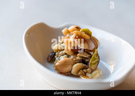 Honig mit Nüssen, Mandeln und Erdnuss Krokant Dessert. Ökologische Lebensmittel. Stockfoto