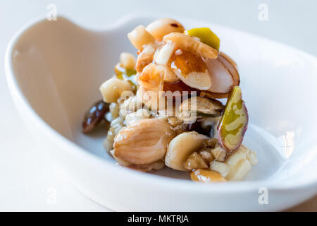 Honig mit Nüssen, Mandeln und Erdnuss Krokant Dessert. Ökologische Lebensmittel. Stockfoto