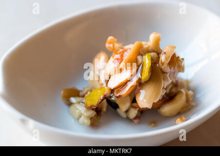 Honig mit Nüssen, Mandeln und Erdnuss Krokant Dessert. Ökologische Lebensmittel. Stockfoto