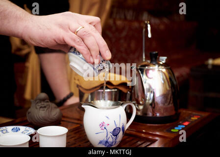 Ein Set für eine Teezeremonie. Der Prozess der Herstellung Tee. Master gießt Kaffee in einer Porzellan Teekanne Stockfoto