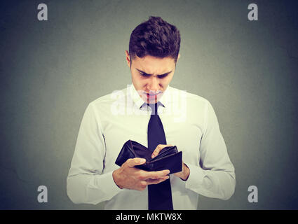 Brach traurig Geschäftsmann mit leeren Brieftasche auf grauem Hintergrund Stockfoto