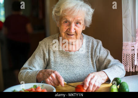 Ältere Frau Gemüse vorbereiten für einen Salat. Stockfoto