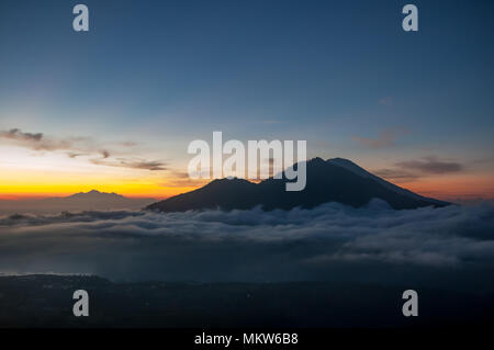 Als sun rückt näher an Horizont, ein Band der hellen gelben, orangen und roten Licht in Inky blau Nachthimmel. In der Nähe Mt Agung ist Silhouette Stockfoto