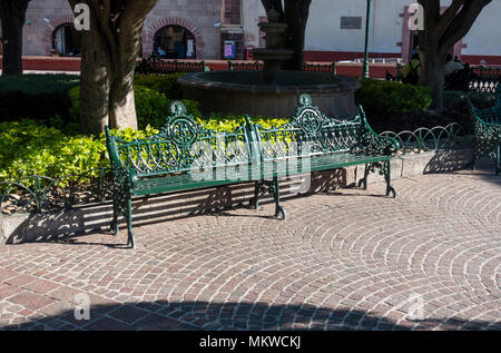 Eine grüne eisen Bank in El Jardin (Der Garten) im Zentrum von San Miguel de Allende in Mexiko, Stockfoto