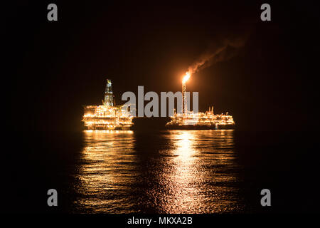 FPSO-tanker Schiff in der Nähe der Bohrinsel in der Nacht. Offshore Öl- und Gasindustrie Stockfoto