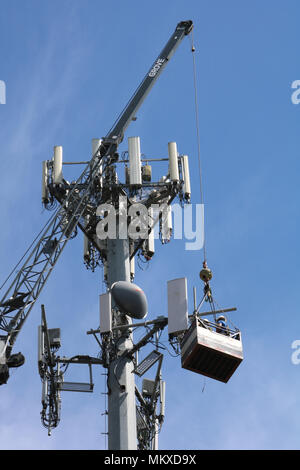 Zwei Männer, die in der Luft verschoben werden über ein Kabel beim Arbeiten auf ein Handy Turm in Ferndale, Washington, USA. Stockfoto