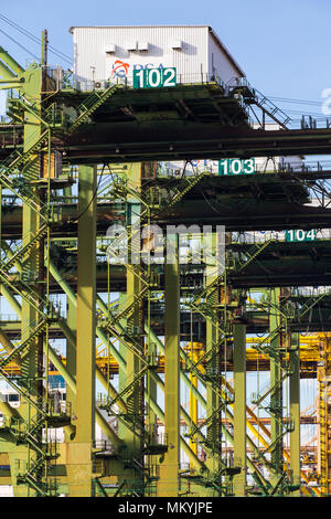 Nahaufnahme der vertikalen Ansicht des Hebevorganges von Containerkranen im Freien. Singapur. Stockfoto