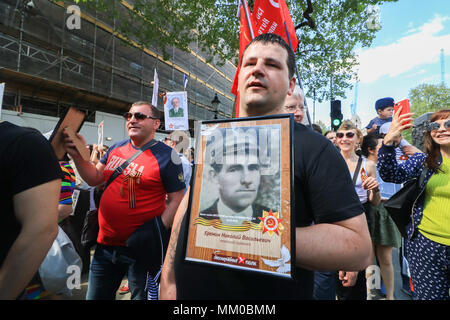 London, Großbritannien. 9. Mai 2018. Mitglieder der Britischen russischen Gemeinschaft nahmen an der Unsterblichen Regiment März Kennzeichnung der Tag des Sieges durch das Zentrum von London mit Blumen und Porträts zu gedenken und erinnern Sie sich, Verwandte, die im Zweiten Weltkrieg gegen NS-Deutschland Credit gekämpft: Amer ghazzal/Alamy leben Nachrichten Stockfoto