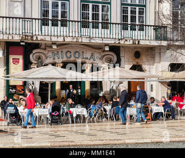 27. Februar 2018: Lissabon, Portugal - Café Nicola, Praça Dom Pedro, mit Kunden draußen sitzen im Winter Sonnenschein, die Art déco-Fassade wurde Stockfoto